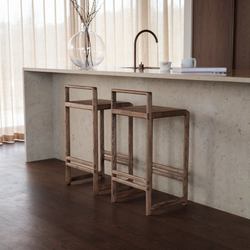 Pair of handcrafted Ebba Bar Stools in dark oak set at a minimalist kitchen island with stone countertop, showcasing timeless Scandinavian design and solid wood craftsmanship.