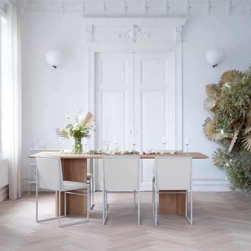 Stylish Ann dining table in oak with white chairs, set for an elegant dining experience in a bright room.