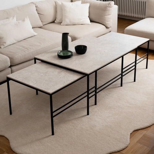 Anton Coffee Table set by by Crea in Sabbia Dekton with a black steel frame, styled in a modern living room. The rectangular nesting design offers flexible functionality with timeless Scandinavian aesthetics.