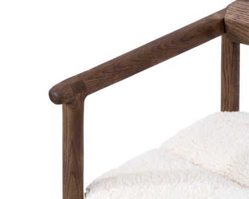 Close-up of Carl Bar Stool armrest in dark oak, showcasing smooth craftsmanship and natural wood grain | by Crea.