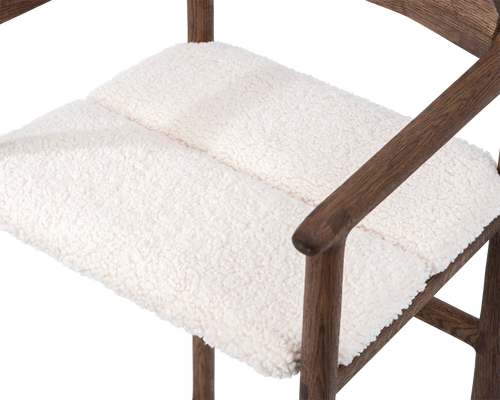 Close-up of Carl Bar Stool seat in ivory bouclé fabric with dark oak frame and armrest detail | by Crea.