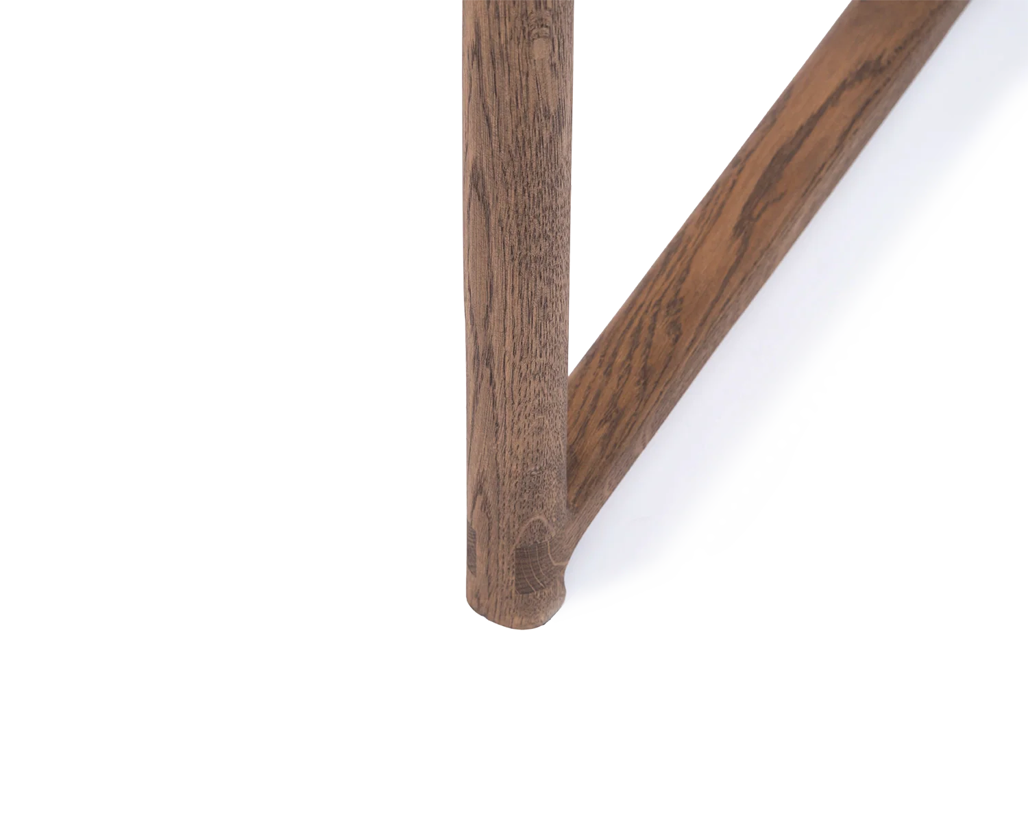 Close-up of Erik Dining Chair foot in dark oak, showcasing the durable joinery and solid wood grain | by Crea.