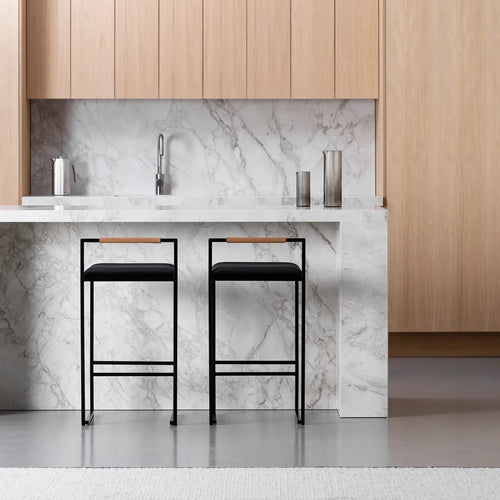 Freja bar stools with black velvet seats and black frames in a modern kitchen with marble countertop.