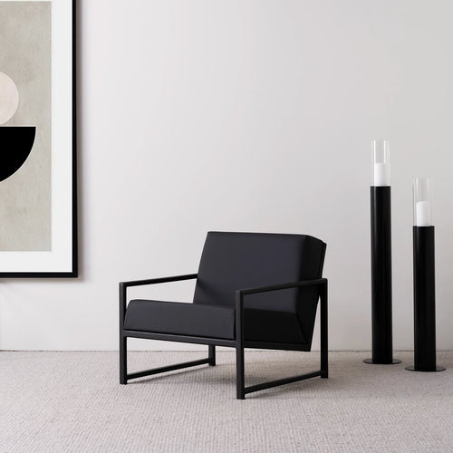 Black oak armchair with jade black leather seat, showcasing sleek Scandinavian design in a modern interior.