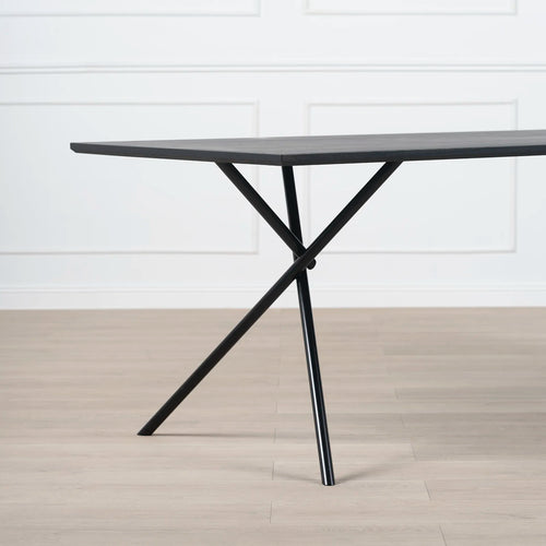 Melker Dining table in black oak with stylish cross legs, perfect for modern dining spaces.