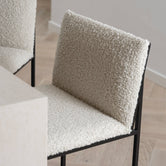 Philip bar stool with an ivory bouclé seat and black metal frame, showcasing modern design and high backrest for comfort.