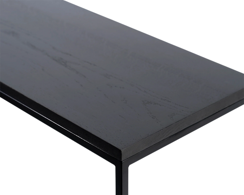 Close-up of corner detail on black oak sideboard top with sleek powder-coated steel frame, highlights natural wood texture and minimalist Scandinavian craftsmanship.