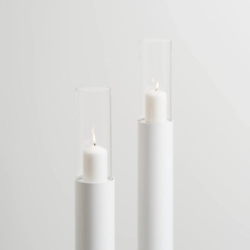 Set of 2 white floor candleholders with minimalist design, featuring candles in elegant glass holders.