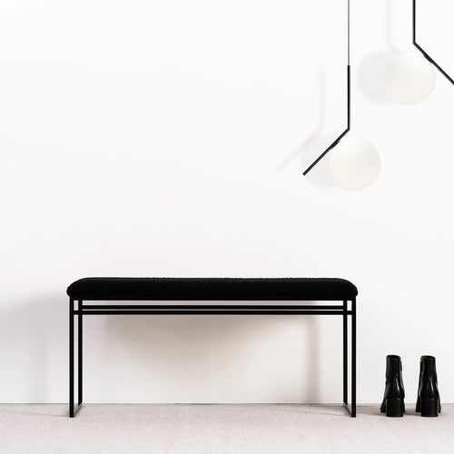 Wilma bench in black bouclé with clean lines, showcasing a minimalist design against a simple background.