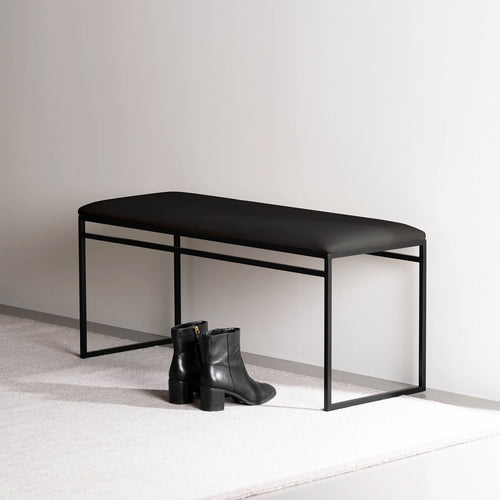 Wilma bench in black with vegan leather seat, minimalist design for modern spaces, paired with black boots.