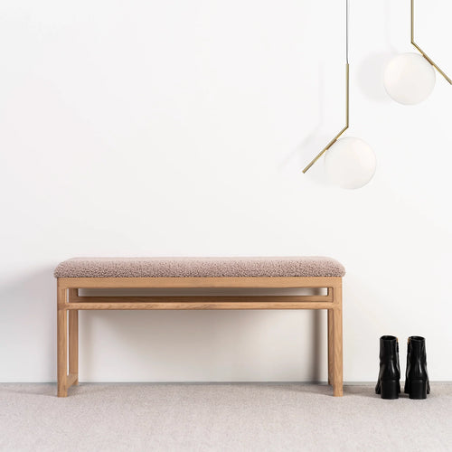 Wilma wood bench in warm oak with greige bouclé fabric, perfect for entryways or bedrooms.