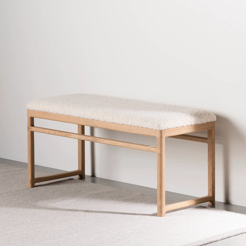 Wilma wood bench in natural oak with ivory bouclé upholstery, perfect for any room decor.