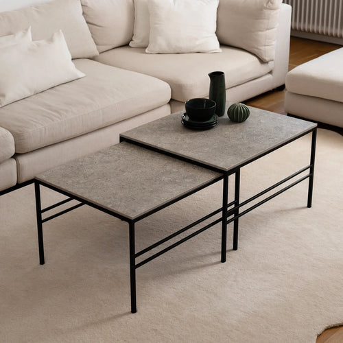 Minimalist Anton Coffee Table set in Grigio Dekton with black frame from by Crea, styled in a Scandinavian living room. The rectangular nesting tables offer functional elegance and timeless durability.