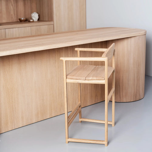 Carl oak bar stool with minimalist design beside a wooden kitchen island, perfect for modern interiors.