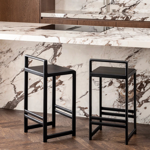 Ebba Bar stool in black oak, perfectly complementing a modern kitchen with stylish marble and wood design.