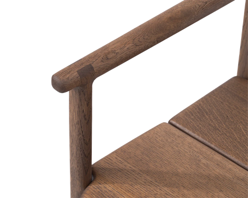 Erik Dining Chair armrest detail in dark oak, highlighting the smooth rounded joinery and craftsmanship | by Crea.
