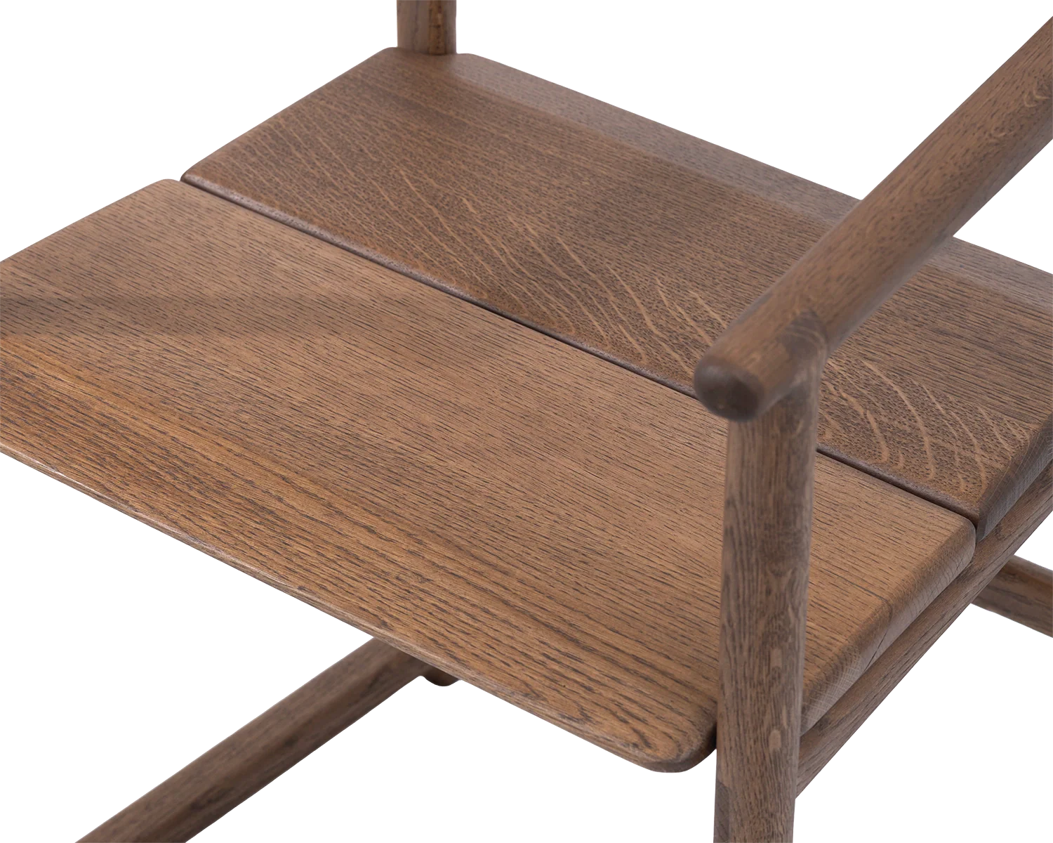 Detail of Erik Dining Chair seat in solid dark oak, showcasing seamless joinery and natural wood grain | by Crea.