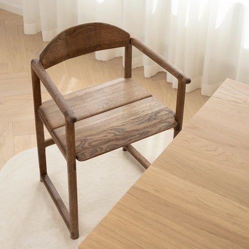 Erik dining chair in dark oak, showcasing a bold sculpted design ideal for any dining table.