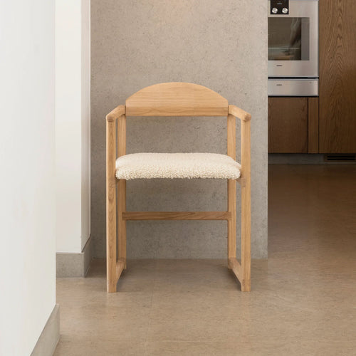 Erik dining chair in oak with ivory bouclé, featuring a warm wood frame and soft seating for relaxed dining.