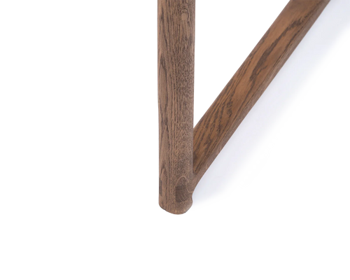 Close-up of Erik Dining Chair foot in dark oak, showcasing the durable joinery and solid wood grain | by Crea.
