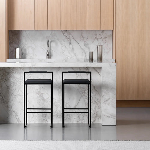 Freja bar stools with black leather seats and frames at a modern kitchen island with marble countertop.