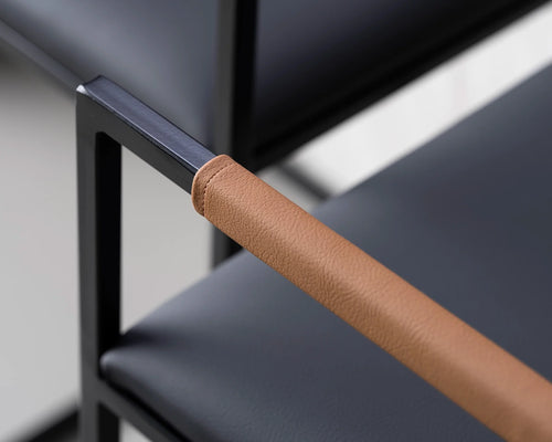 Close-up of Freja Barstool backrest featuring black steel frame and tan vegan leather armrest wrap – Scandinavian design by Crea.