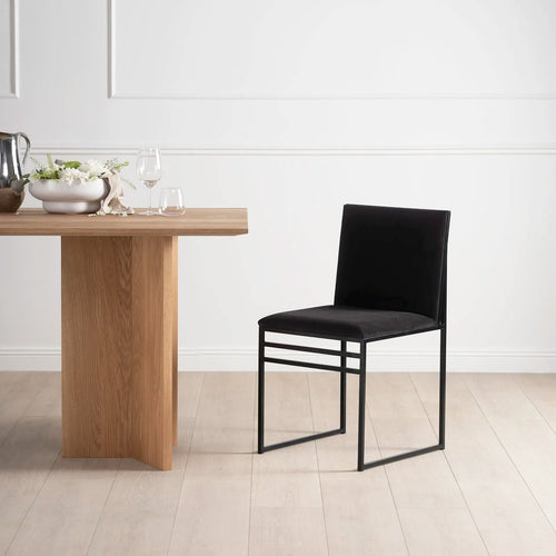Isabell black velvet dining chair with matching frame in modern dining space, elegant design for a refined look.