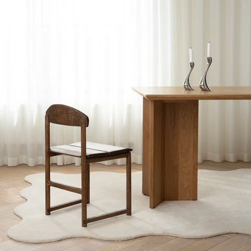 Karin dining chair in dark oak with elegant grain, paired with a modern wooden table and minimalistic decor.