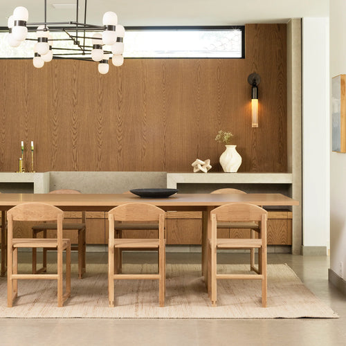 Karin dining chairs in oak arranged around a stylish dining table in a modern Scandinavian-inspired setting.