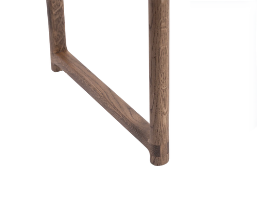 Close-up of the Karin Dining Chair leg in solid oak, highlighting rounded corner joinery and smooth wood grain in a Scandinavian minimalist design.