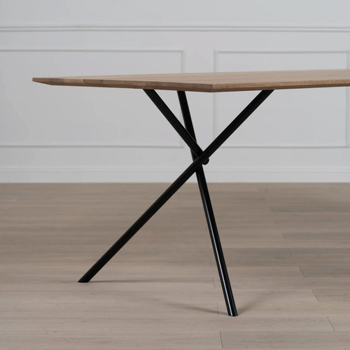 Melker dining table in black and natural oak with modern design and unique x-shaped legs.