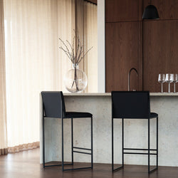 Modern Philip bar stools with black leather seats and black frames, set at a contemporary kitchen island.