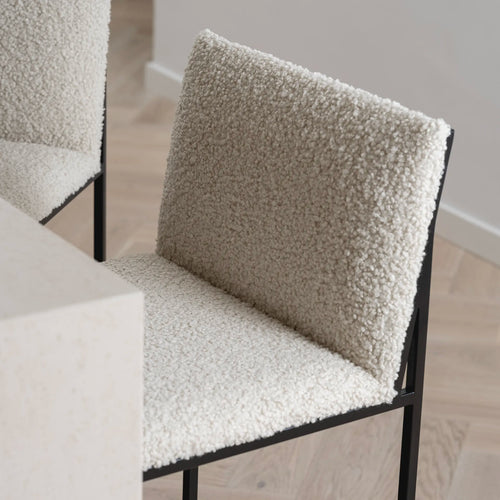 Philip bar stool with an ivory bouclé seat and black metal frame, showcasing modern design and high backrest for comfort.