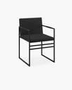 Sella dining chair in black leather with black armrests, featuring a sleek matte black finish for luxury comfort.