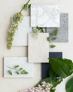 Various Dekton stone samples with natural greenery to help choose the perfect surface.