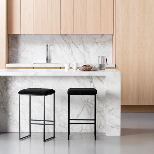Svea bar stools with black bouclé seats and black frames in a stylish kitchen setting.