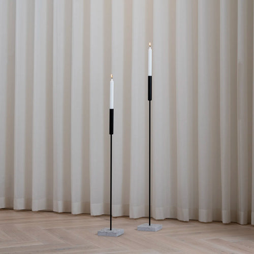 Vera Floor candleholder set in black, minimalist steel design with white candles for elegant ambient lighting.